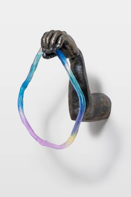une sculpture représentant une main tenant une brosse à dents dans sa bouche
