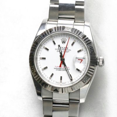une montre argentée avec une trotteuse rouge sur fond blanc