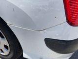 the rear end of a white car with a broken tire