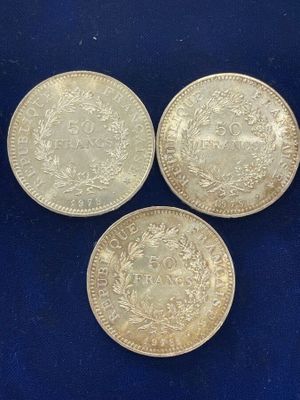 three silver coins on a blue background