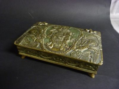 a brass box with a design on it on a table