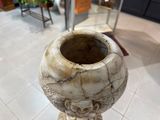 un vase posé sur un socle dans une pièce