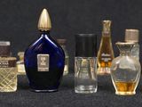 many different bottles of perfume on a black surface