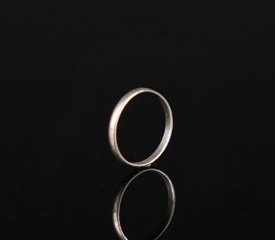gros plan d'une bague en argent sur une surface noire