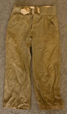 an old pair of pants sitting on a carpeted floor