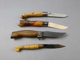 several knives are lined up on a table with a white background