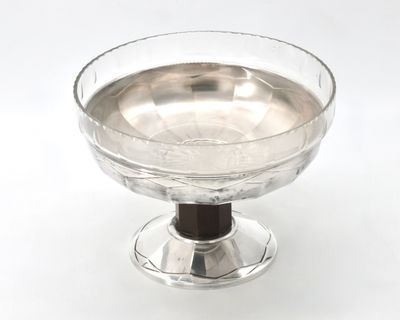 a glass bowl with a wooden base on a white surface
