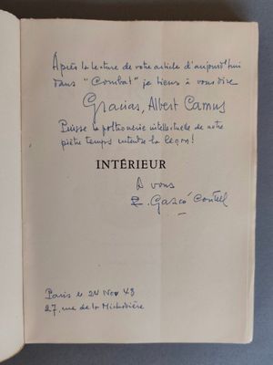 un livre ouvert avec une écriture dessus, posé sur une table