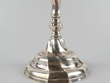 an antique silver plated candle holder with a bird on it