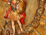 a statue of an angel holding a sword on a wall