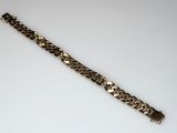 a close up of a metal bracelet on a white surface