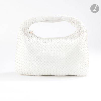le sac tissé blanc est posé sur une surface blanche