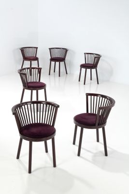 Plusieurs chaises sont disposées en cercle dans une pièce blanche.