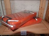 deux sacs orange posés sur une étagère en bois