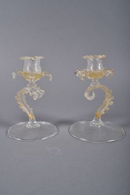 two clear glass candlesticks sitting on top of each other on a table
