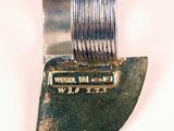 a knife that is sitting on top of a piece of metal