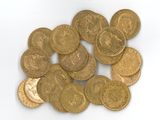 une pile de pièces d'or posée sur une surface blanche