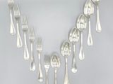a lot of silver spoons and forks on a table