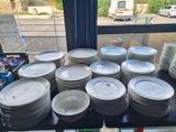 a lot of plates on a table in front of a window