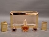 three bottles of perfume in a gold box on a table