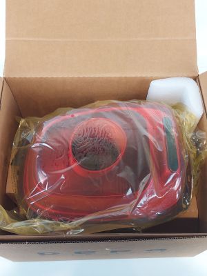 une boîte contenant un objet rouge, posée sur une surface blanche