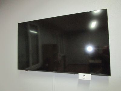 un téléviseur à écran plat fixé au mur d'une pièce