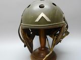 un vieux casque d'où sort un bâton sur le côté