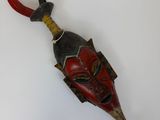 une image d'un masque en bois accroché au mur