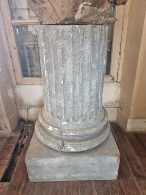 a statue of a man sitting on top of a pedestal