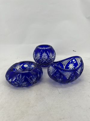 three blue glass beads sitting on top of a white surface