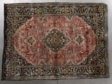 an antique rug with a medallion design on a black ground