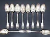 six cuillères en argent sont alignées sur une table