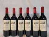 six bouteilles de vin sont alignées sur une table