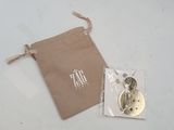 a small bag with a button on it next to a bag of buttons