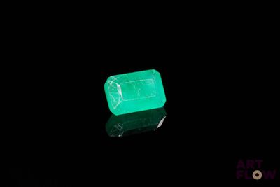 un gros plan d'une émeraude verte sur une surface noire