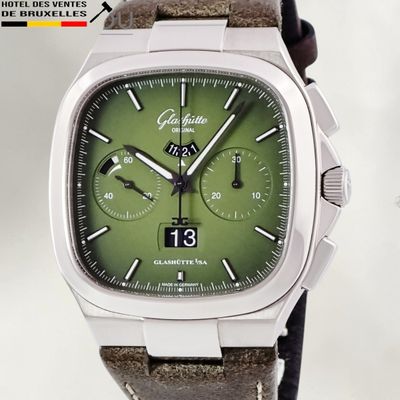 a close up of a watch with a green face
