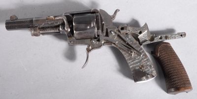 un vieux pistolet avec une poignée en bois sur une surface blanche