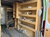 the back of a van with shelves and tools in the back