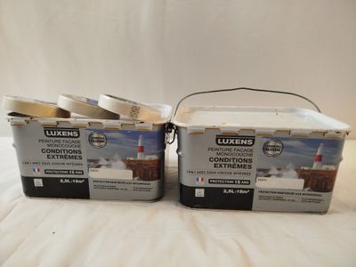 deux seaux de peinture posés sur un lit