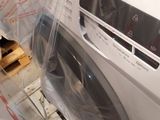 a washing machine wrapped in plastic and ready to be loaded