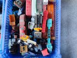 un panier en plastique bleu rempli de petites voitures et de petits camions