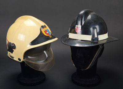 deux casques de pompier posés l'un sur l'autre sur la tête d'un mannequin