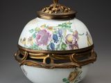 un vase blanc et doré orné de fleurs