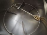 a metal bowl with a wooden spoon and spoon rest on top of it