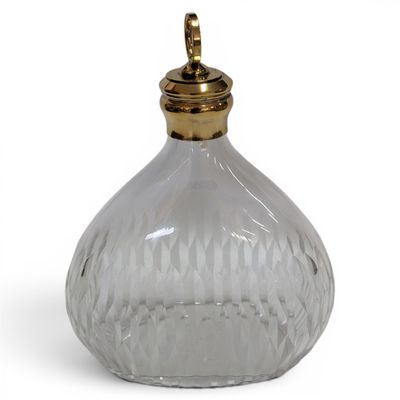 an image of a clear glass bottle with a gold top