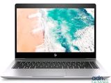 the laptop is open on a white surface with a beach in the background