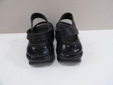 pair of children ' s black leather shoes on a white surface
