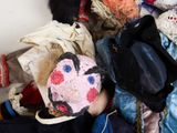a pile of clothes and a hat with a face painted on it