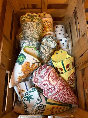 une caisse en bois remplie de nombreuses pièces de poterie de toutes sortes