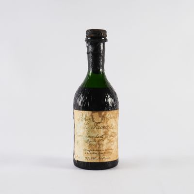 une vieille bouteille de vin posée sur une surface blanche